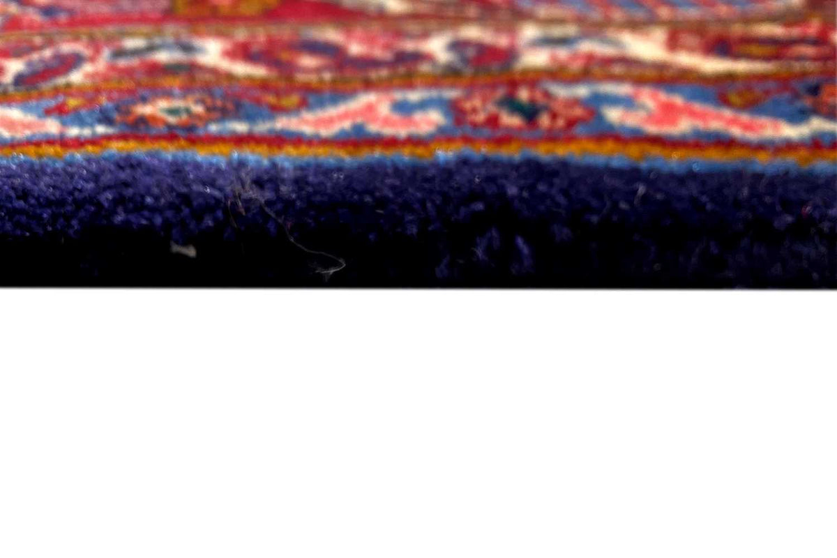 Close-up of a Khorasan oriental rug: rug edge with dark pile and a colorful border