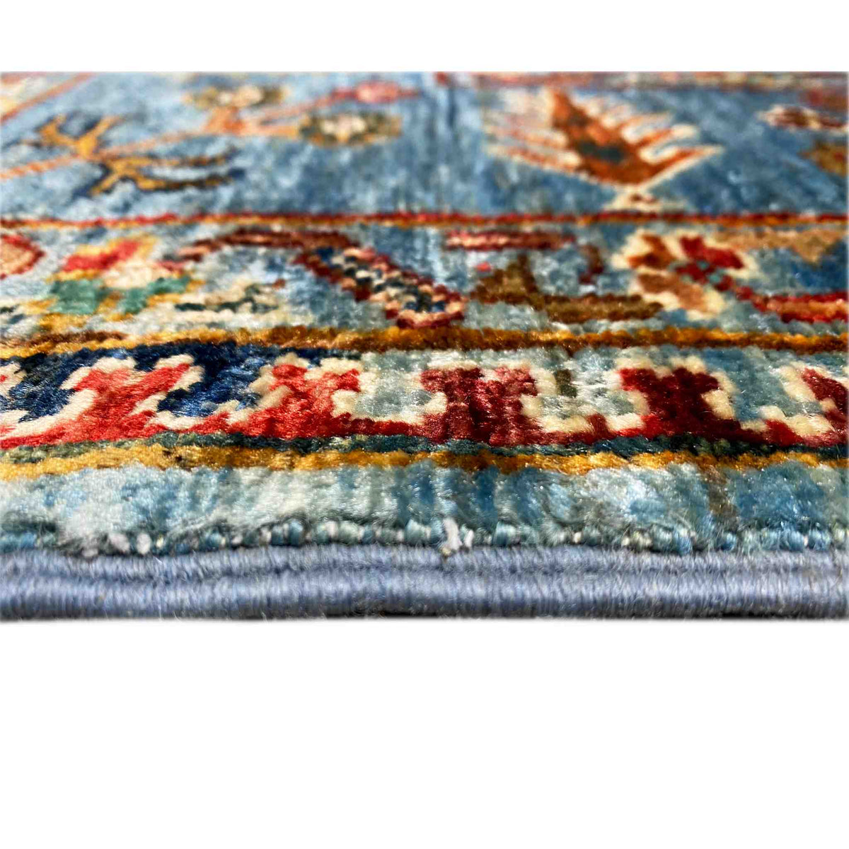 Close-up: blue Khorjin rug with colorful ornaments and fringes