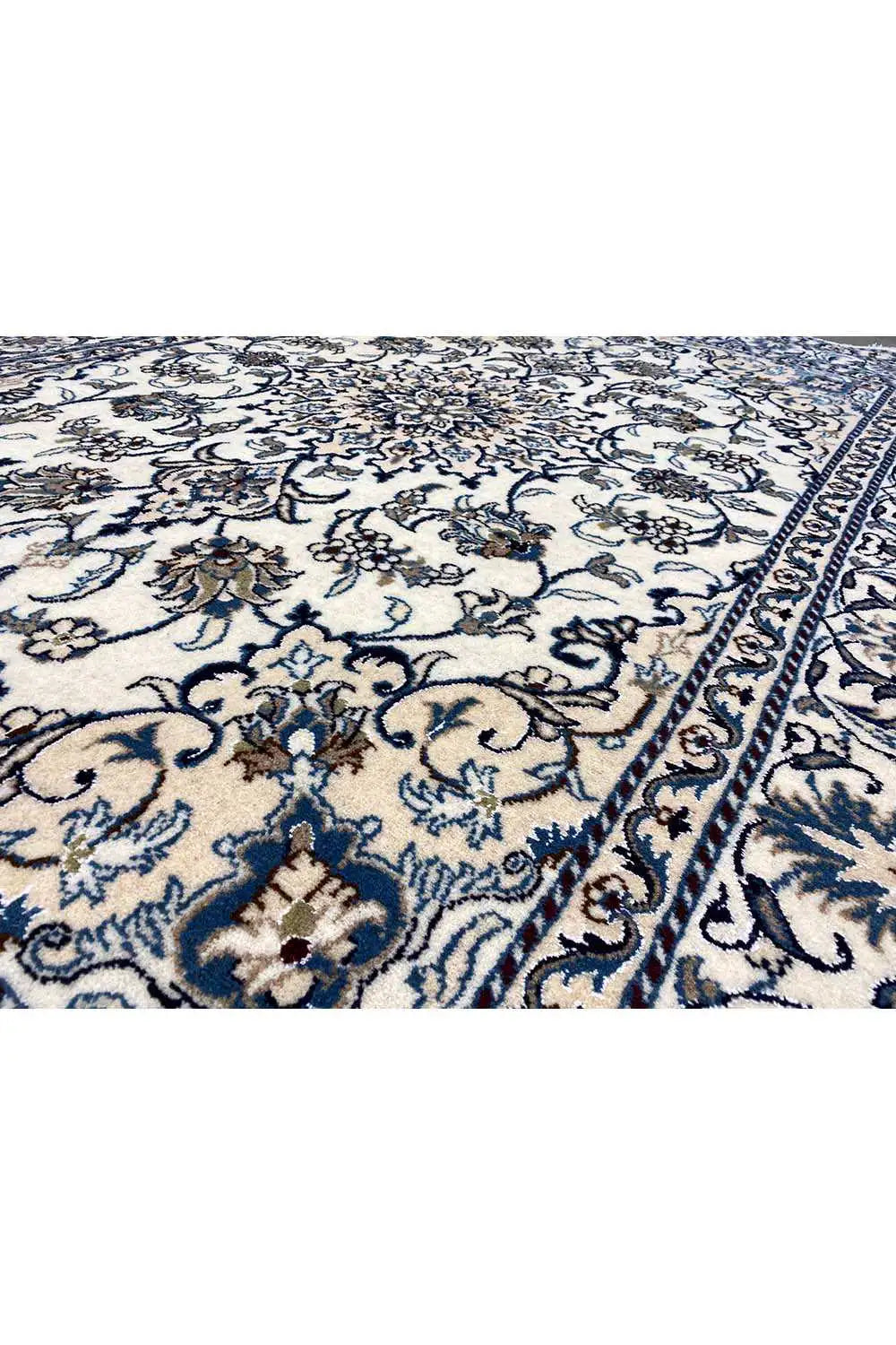 Close-up: blue-and-white Nain rug with delicate floral motifs and borders.