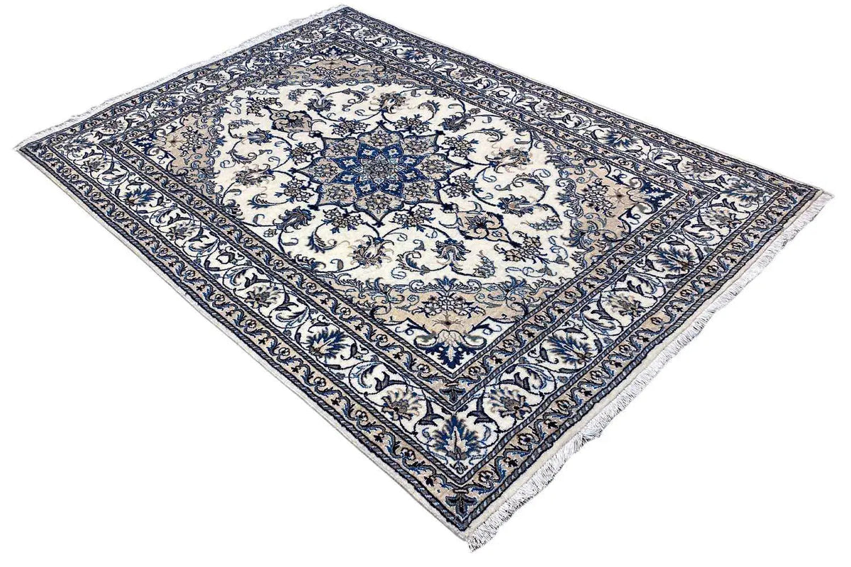 Nain rug at a diagonal angle: blue-and-white medallion pattern, with a decorative border