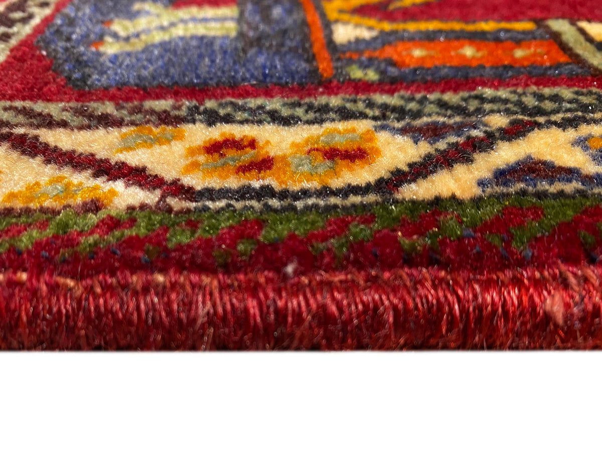 Poshti rug (59×61 cm) close-up: red pile and colorful borders with fringes