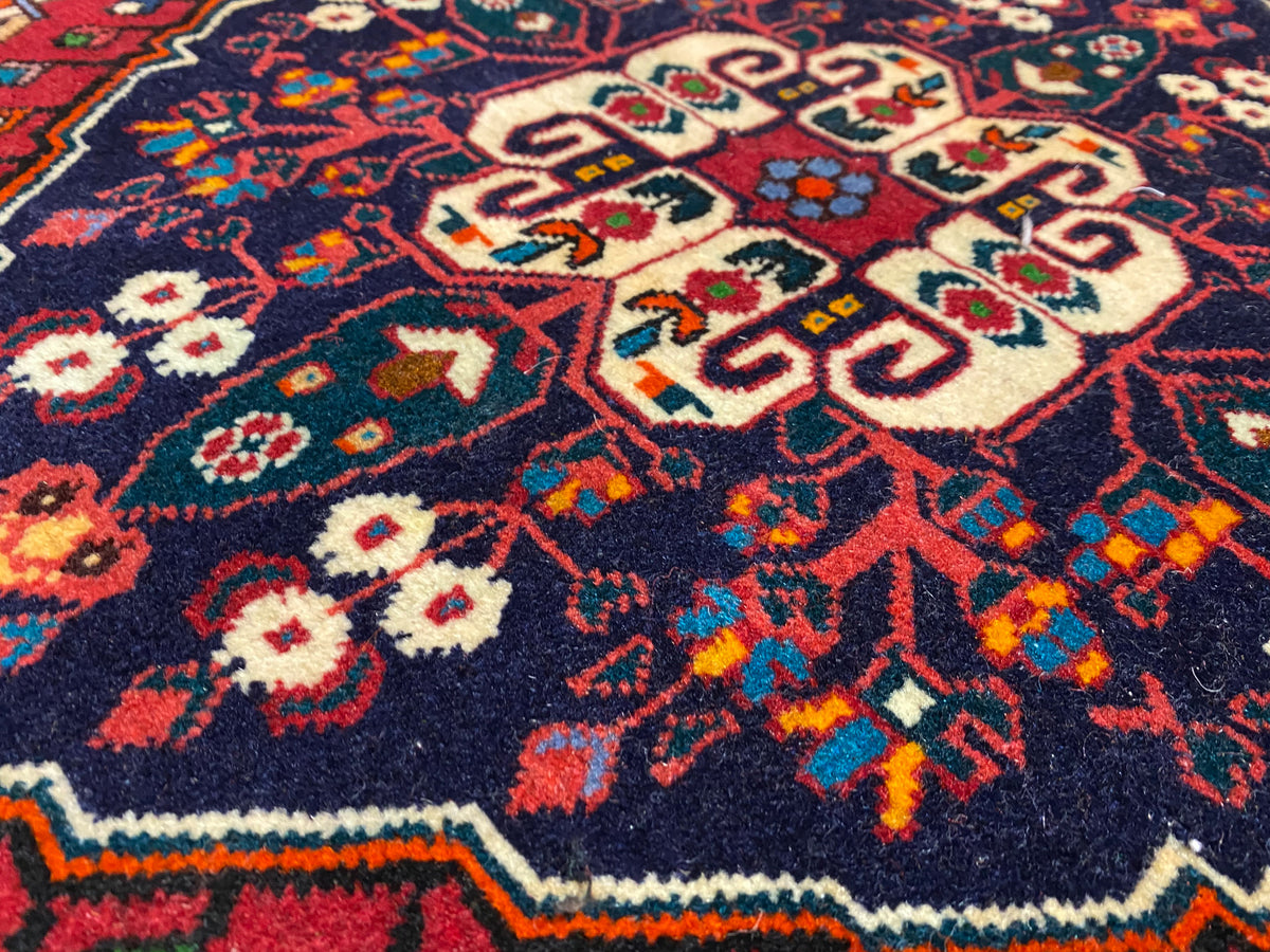 Close-up of carpet pile with colorful ornamentation in blue, red, cream, and green