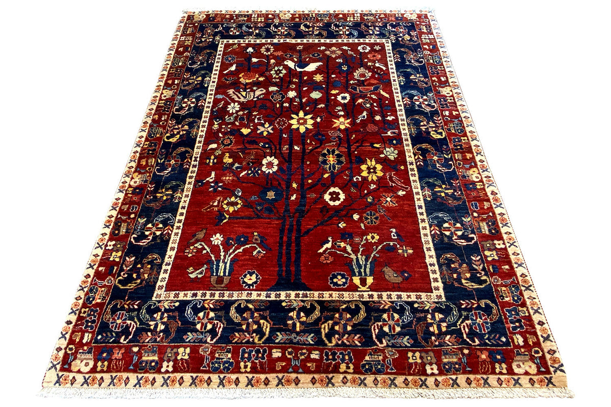Oriental rug, red field with tree and animal motifs, blue-and-white border