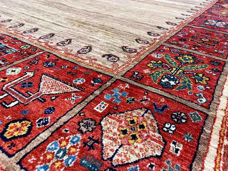 Close-up: red patterned area with colorful ornaments and a beige border on the carpet