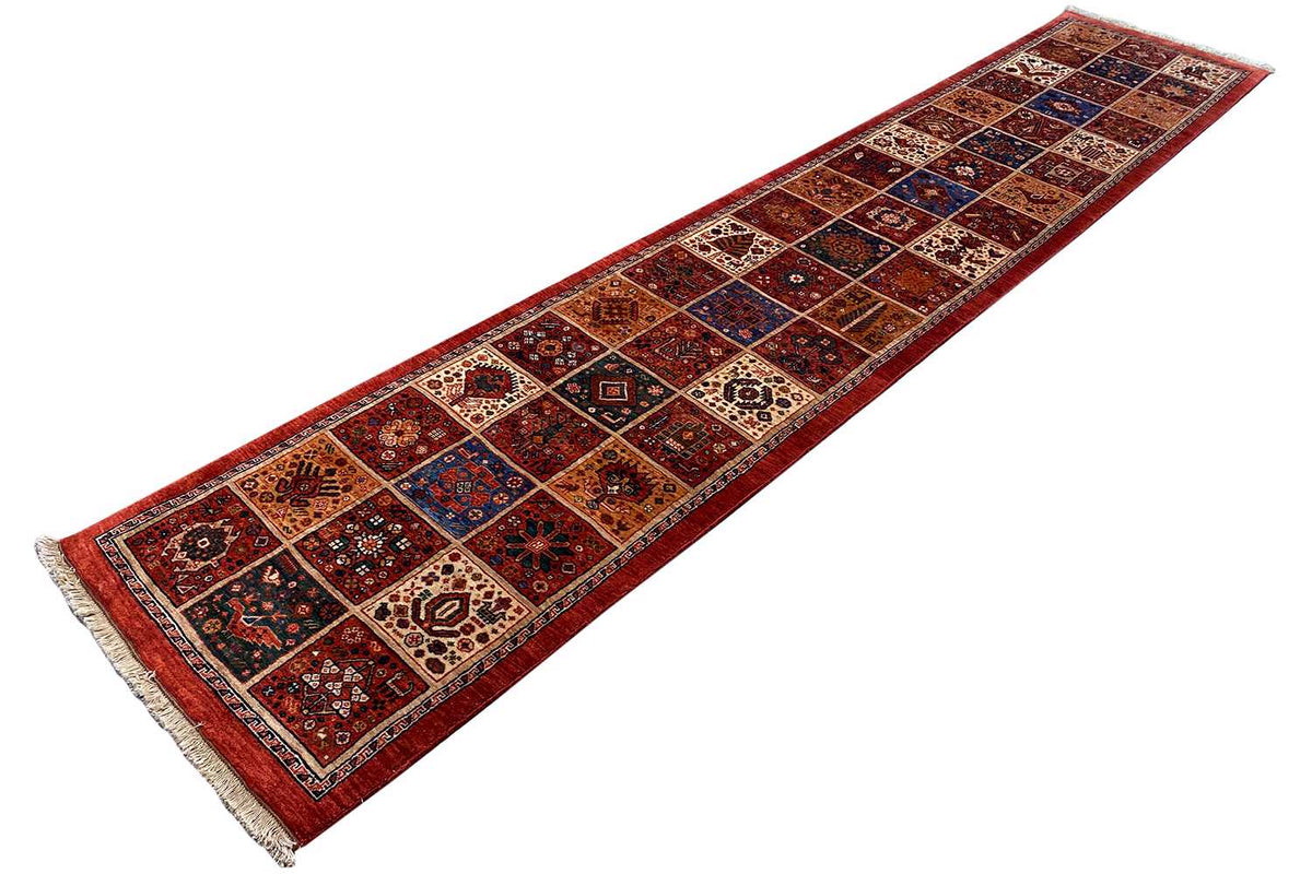 Qashqai exclusive runner rug in a diagonal view, red border design with rows of ornaments
