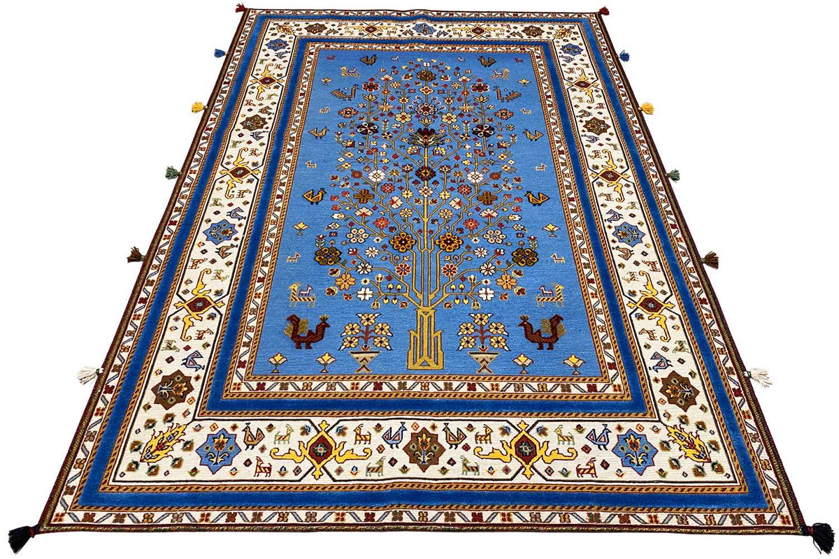 Blue oriental rug, laid flat, with a colorful border and corner fringes