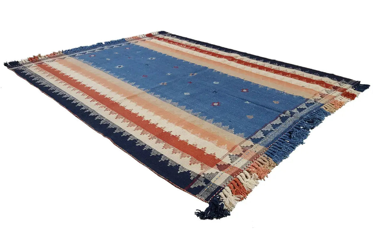 Rectangular rug seen from above: blue field, red-and-cream striped, with fringes.