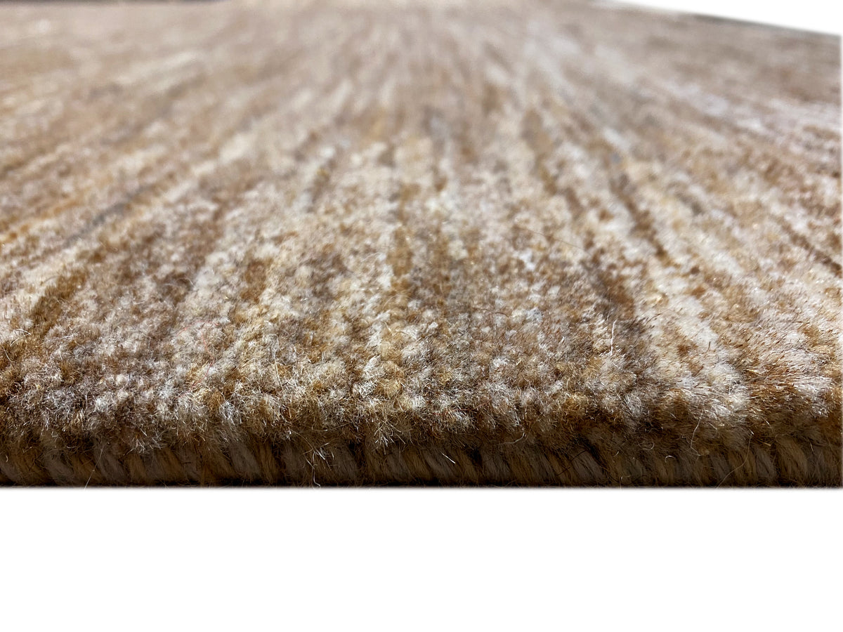 Gabbeh rug detail: brown-beige pile, compact short-pile texture at the edge