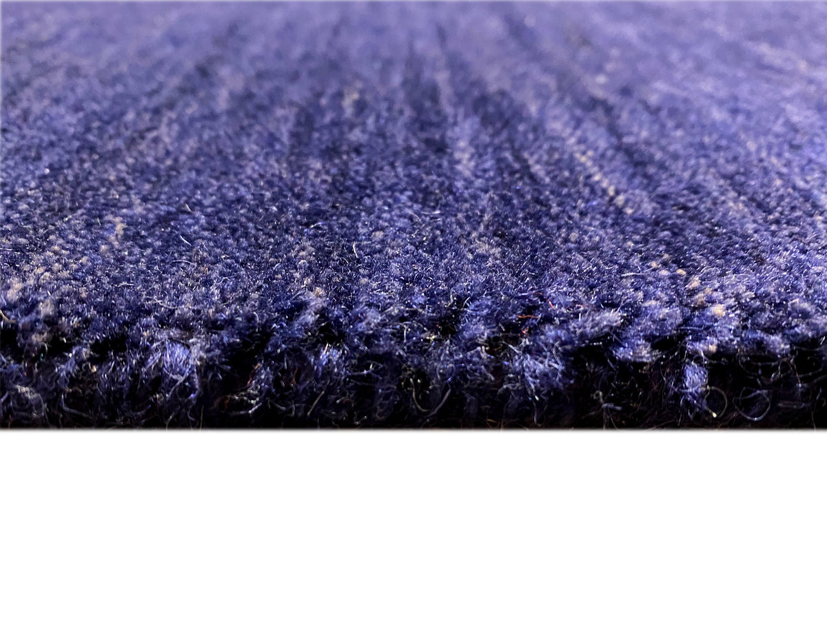Blue short-pile rug with a dense, textured surface and a subtle pile variation.