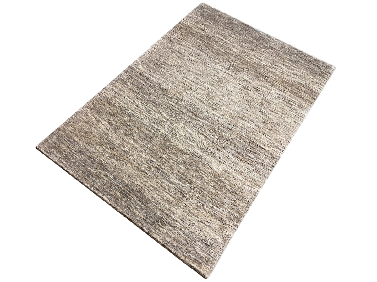 Rectangular Gabbeh rug, photographed diagonally, mottled gray-brown finish