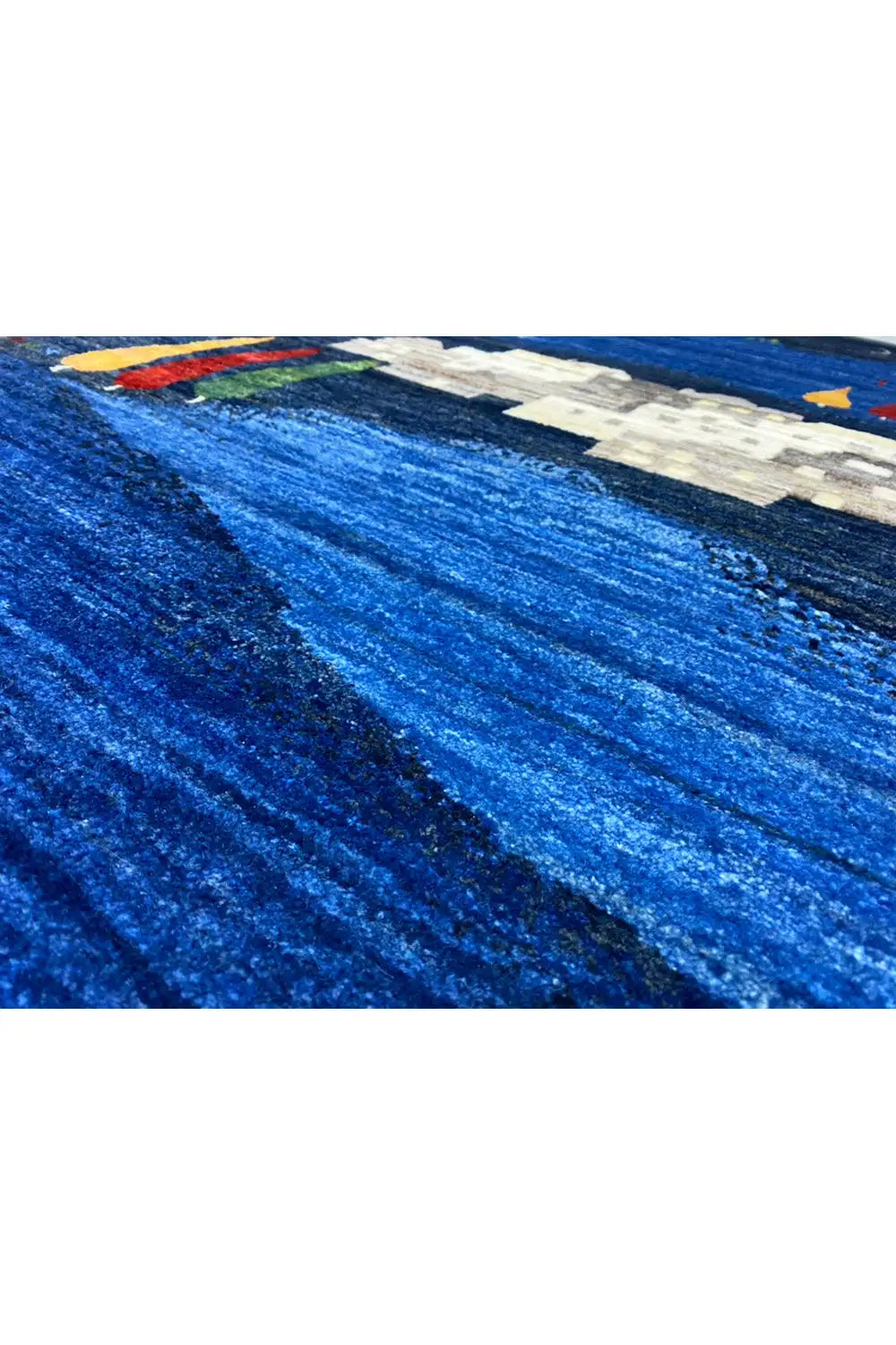 Gabbeh rug, detail of the blue striped structure with a white building and colorful accents