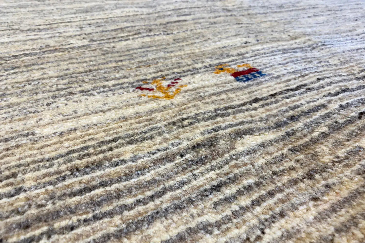 Carpet detail with colorful patterned dots between dark gray lines on a light background
