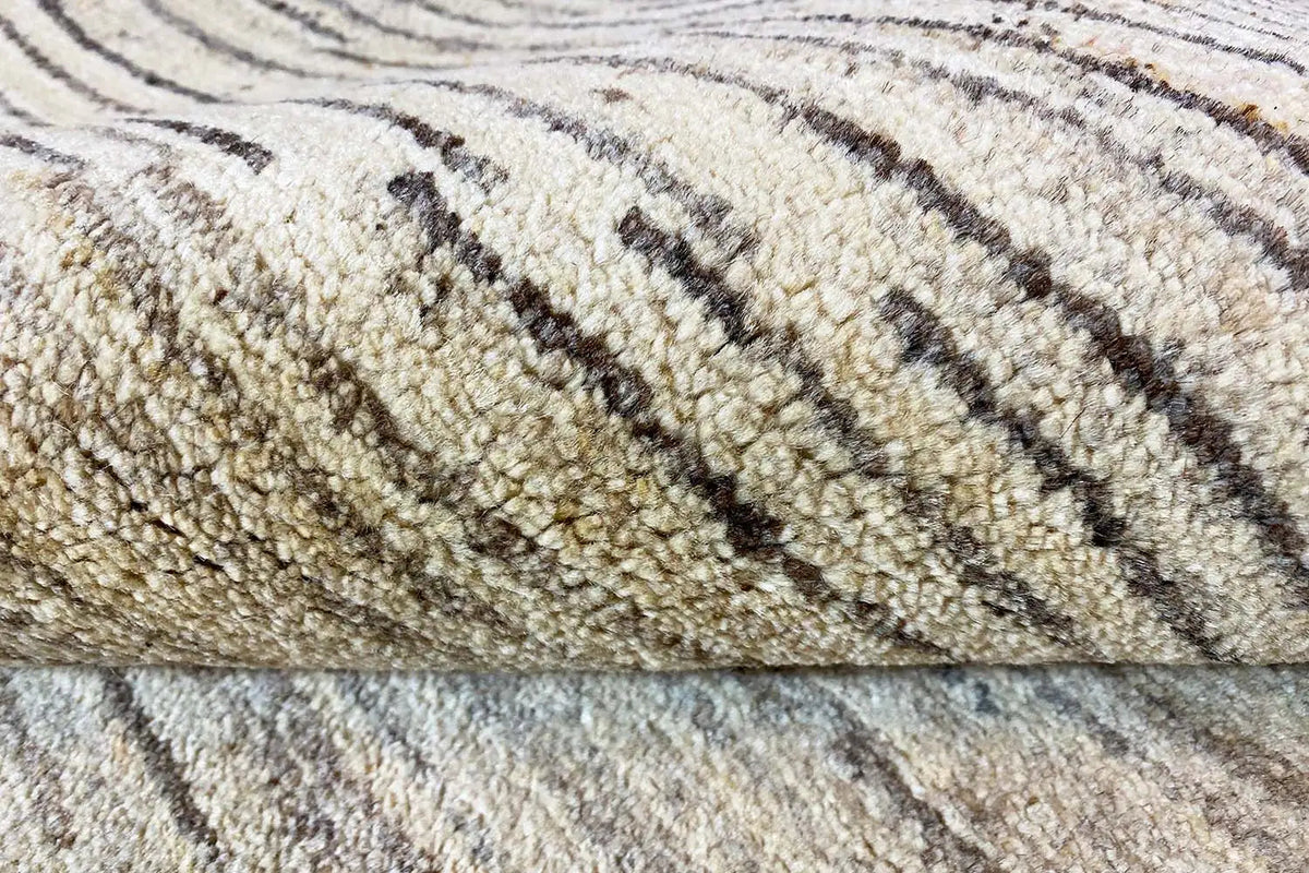Carpet detail with a light background and straight, dark brown lines in an abstract pattern