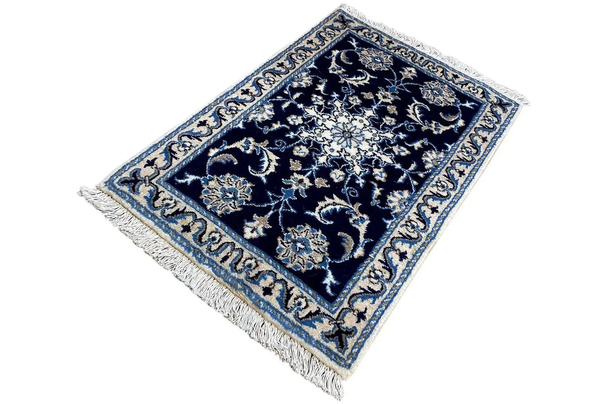 Rectangular rug with floral patterns in dark blue, light blue, and cream, with fringes