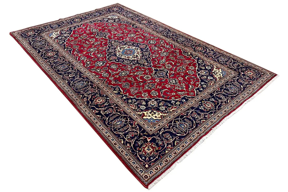 Keshan carpet, red field with dark blue border, diagonal view