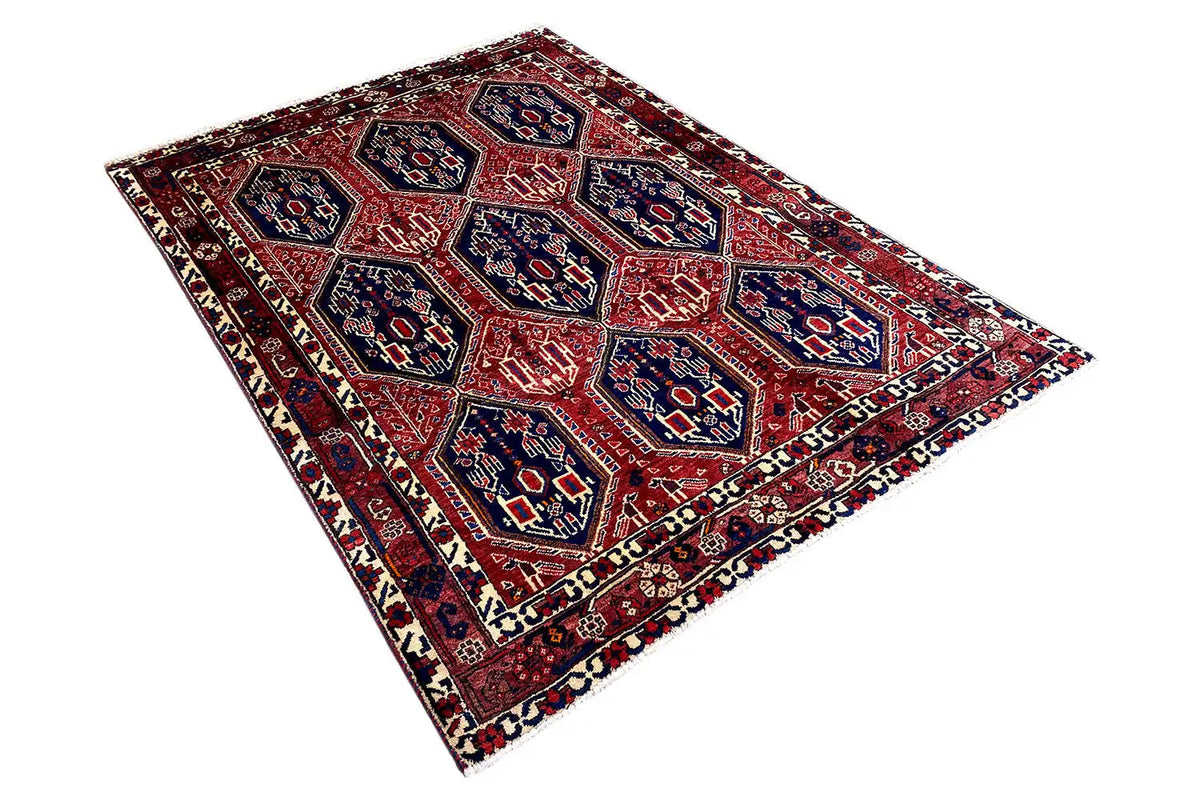 Oriental rug laid flat: red ground pattern with blue-outlined medallions