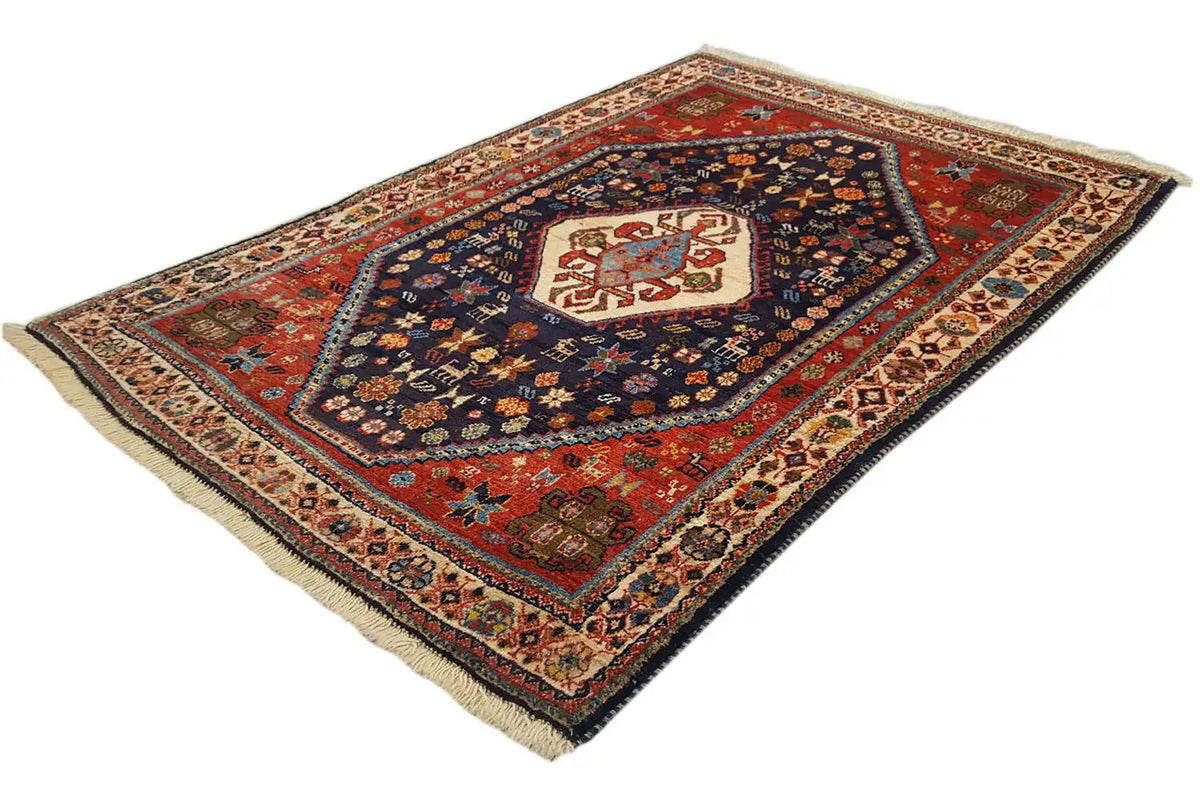 Oriental rug with a blue central medallion, red field, and corner ornaments