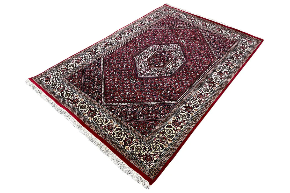 Rug laid out: burgundy ornamental field with a border pattern and white fringes