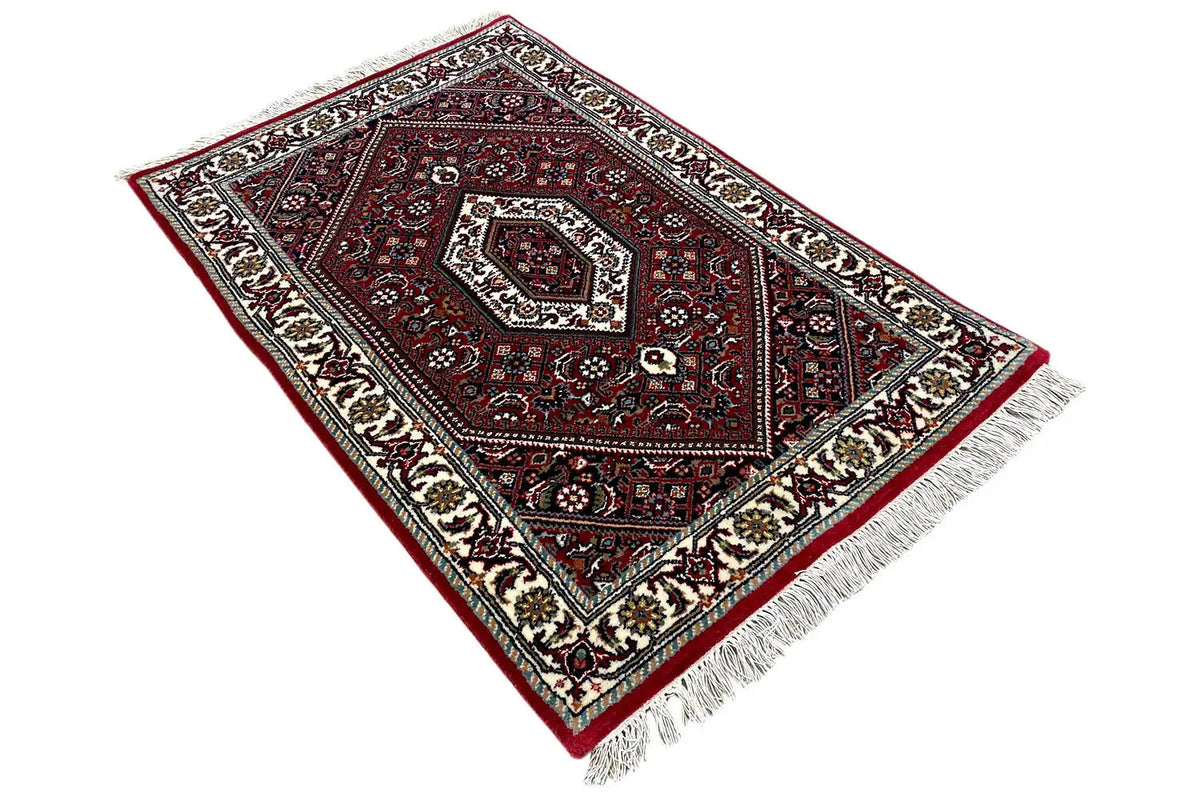 Bidjar rug (94×62 cm): Diagonally positioned rug with a red background and geometric embellishments