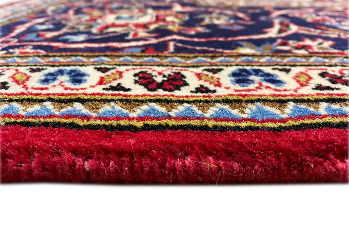 Keshan rug: deep-pile red cut pile with a colorful patterned border stripe