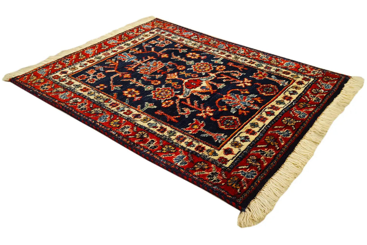 Square rug with a dark blue pattern, red border, and light beige fringes