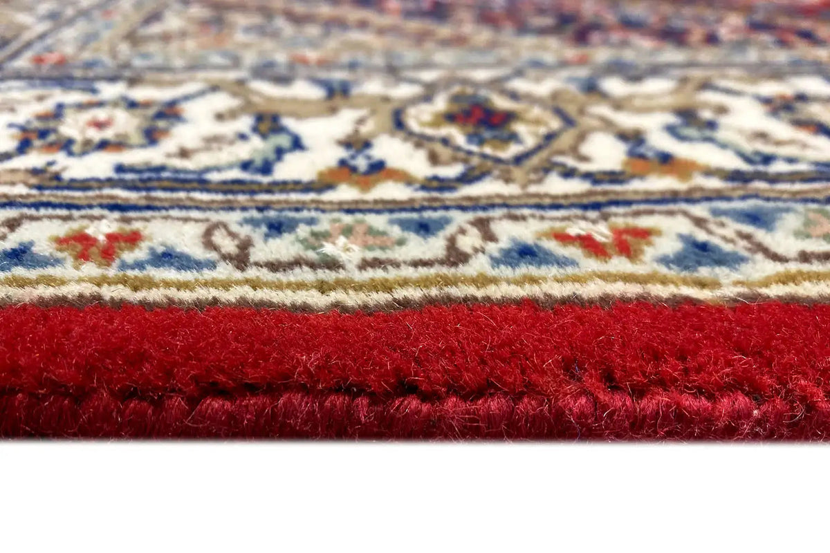 Bidjar runner edge with red pile, blue-and-white patterned border and fringes
