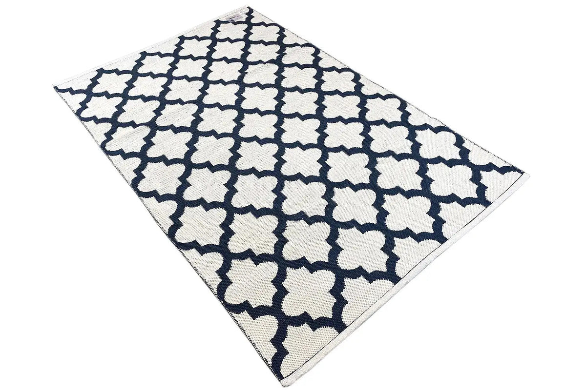 Kilim rug at a diagonal: dark blue and white geometric pattern, laid flat