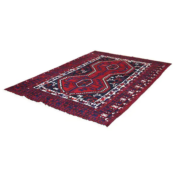 Rectangular Oriental rug with a red background, blue medallion, and white-bordered border