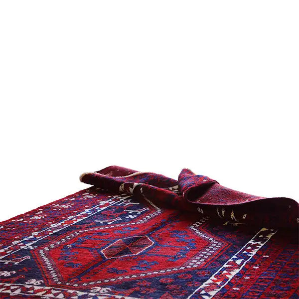 Close-up of an Oriental rug: folded fabric edge with a red and blue pattern