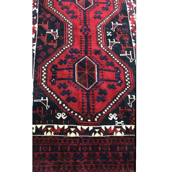 Oriental rug detail: symmetrical pattern with a central square and a narrow decorative border