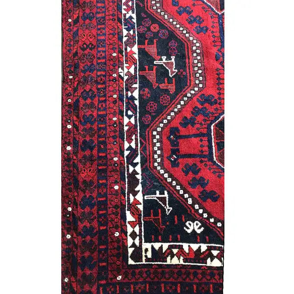 Side view detail: red carpet edge with white ornaments and blue motif band