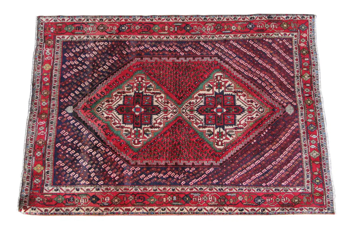Oriental rug with a red central medallion and blue pattern, border with ornaments.