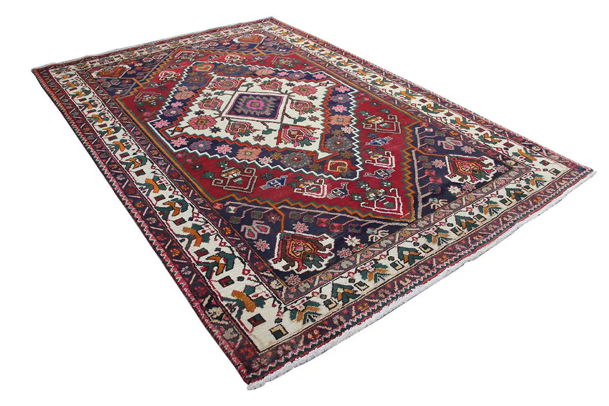 Oriental rug in diagonal view, red and dark blue, central tile frame, border