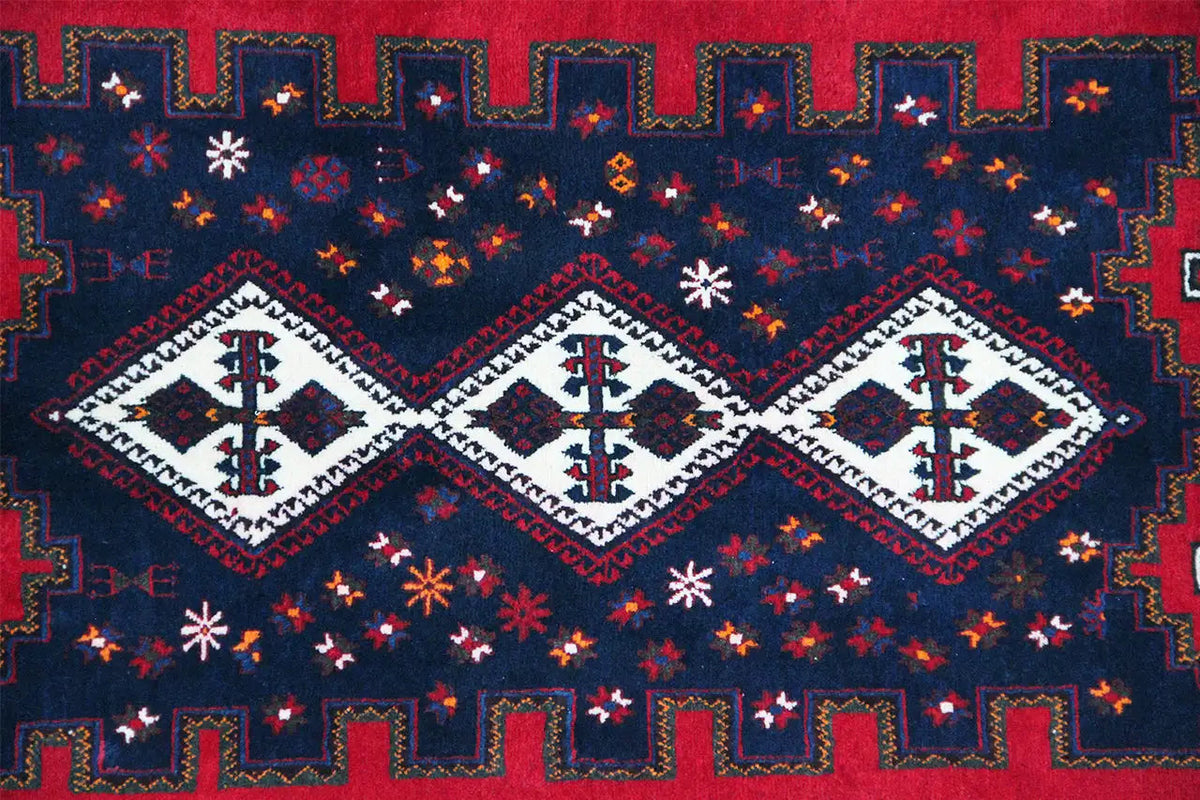 Multicolored rug with a geometric pattern in blue, red, and white