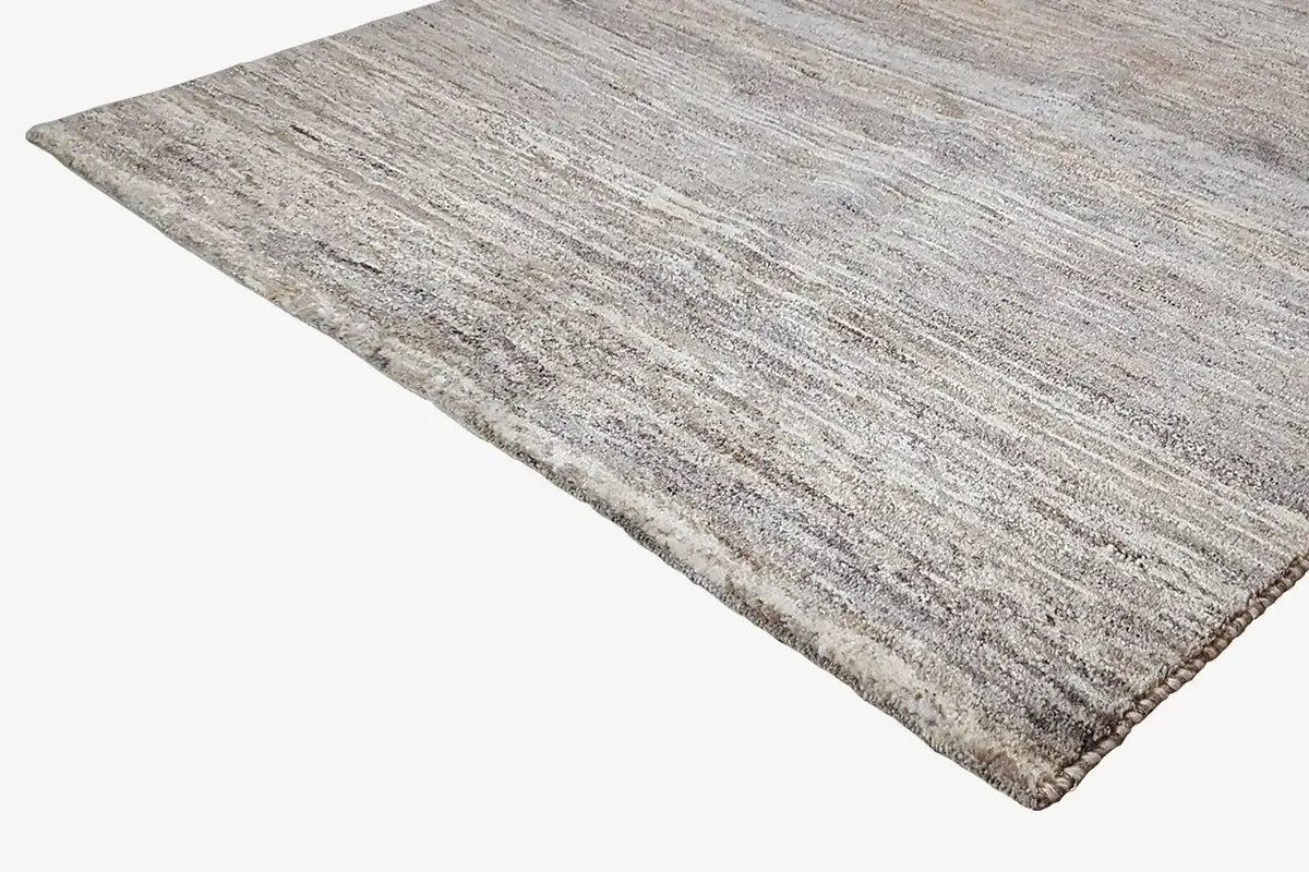Gabbeh rug, photographed at an angle, heathered flat weave in natural gray