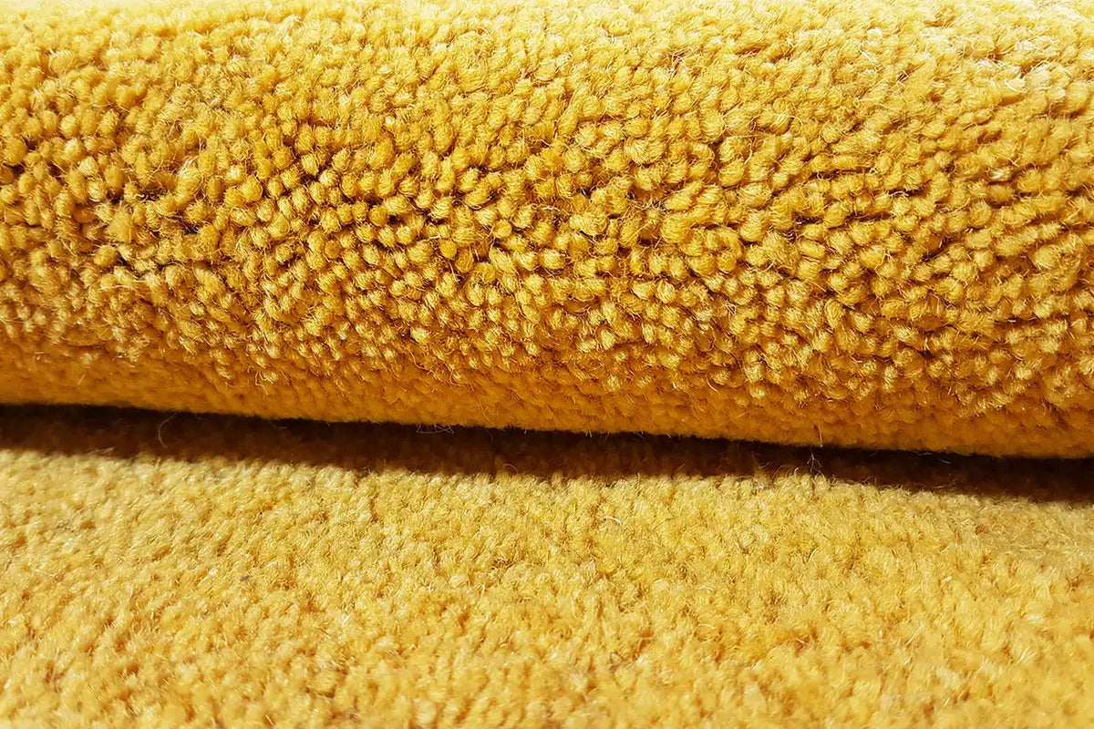 Close-up of a Gabbeh rug: dense pile in mustard yellow