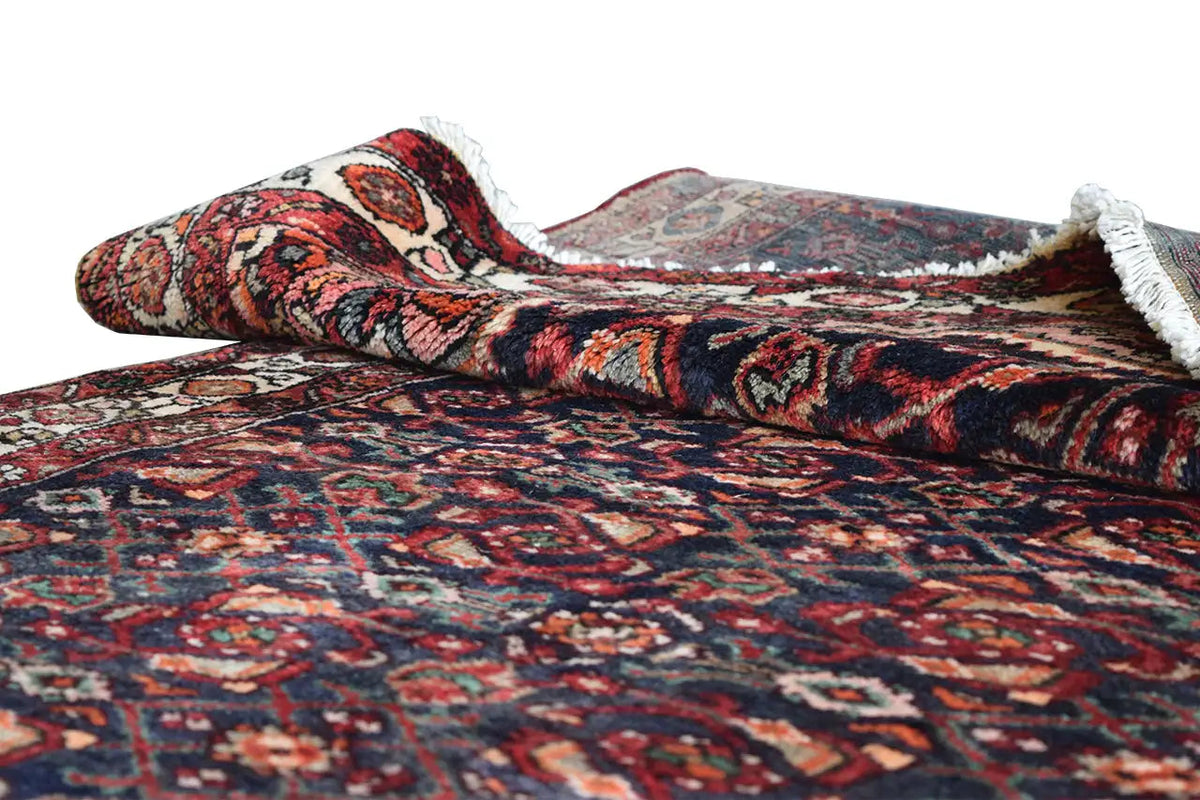 Oriental runner rug with a pattern and white fringed border, dark blue background with red and beige details.