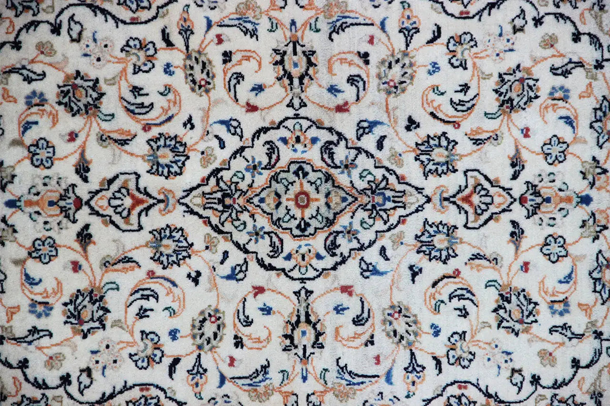 Close-up of the beige Keshan rug with a blue and red ornamental pattern