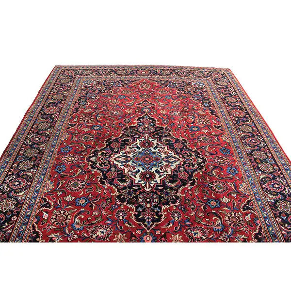 Keshan rug with a red background, dark medallion, and ornamental pattern