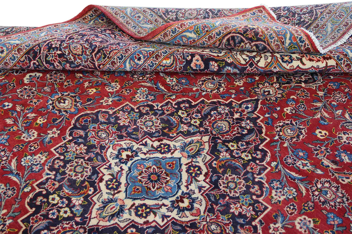 Keshan oriental rug in red with a blue pattern, knotted, folded view