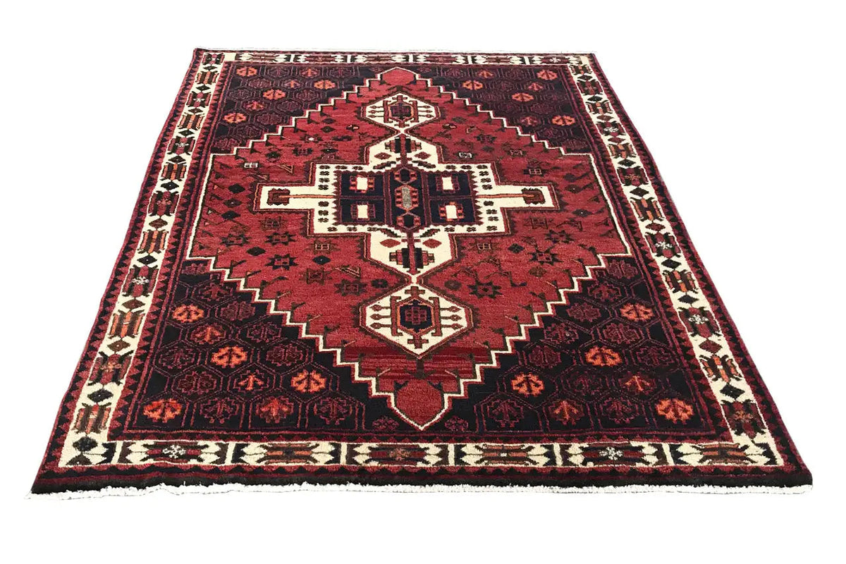 Rug with a red border design, dark background, and central medallion