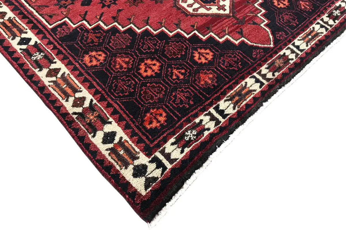 Carpet corner with a red background, zigzag border, and dark diamond ornaments