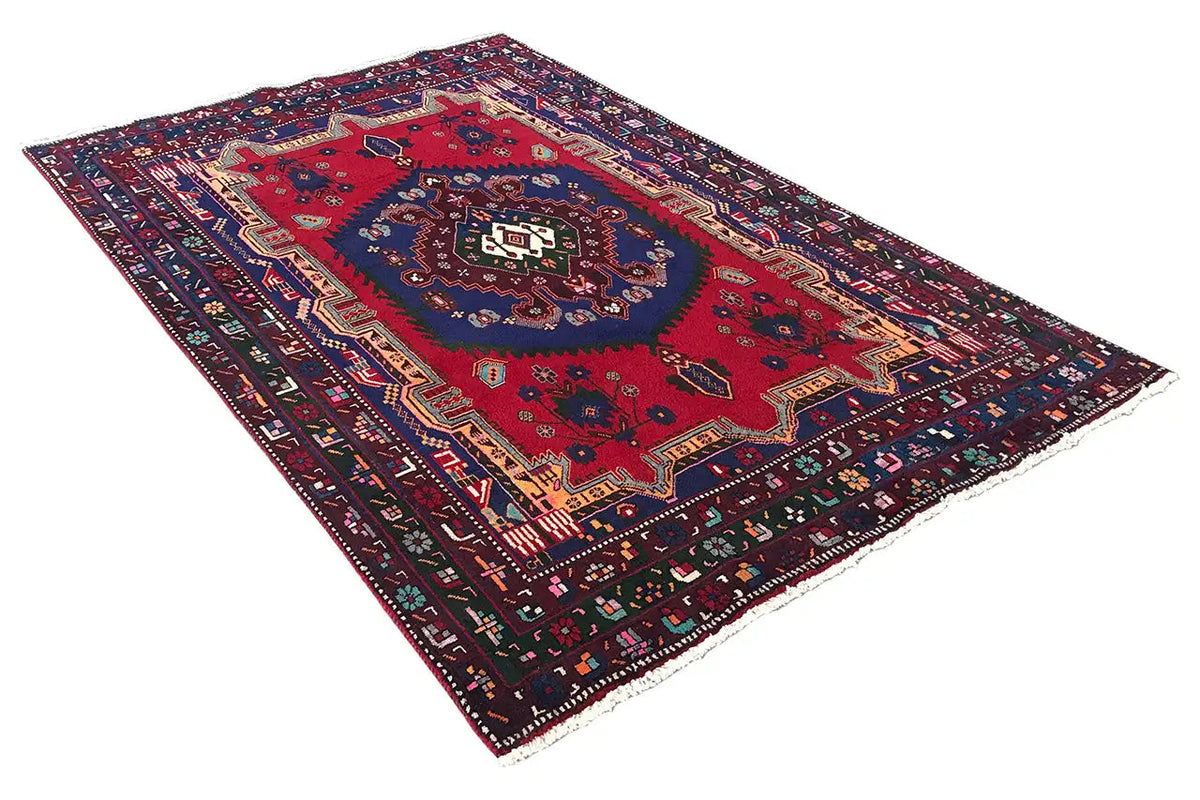 Sirjan rug (250×166 cm) with a red pattern, blue central field, and decorative border
