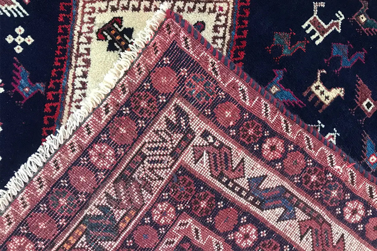 Oriental rug detail: woven texture with a lustrous thread, red and cream-colored patterns