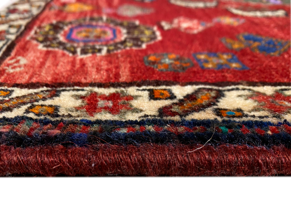 Detail Poshti rug 58x57 cm: red pile, colorful patterned border and short fringe trim