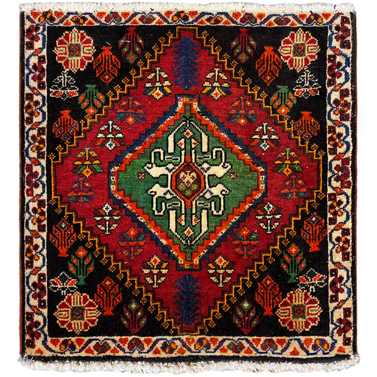 Poshti rug, square: black woven rug with red, green, and blue decorative pattern