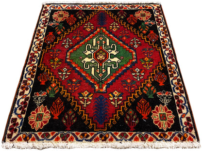 Square Poshti rug, black background with a central pattern in green, red, and blue