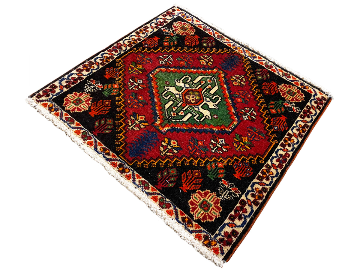 Poshti square rug, diagonal: black woven rug with a green-red central pattern