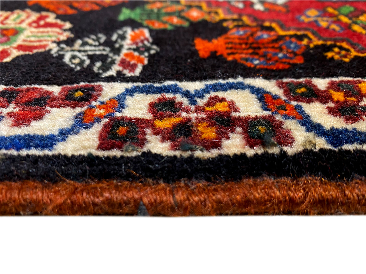 Poshti rug edge detail: multicolored border and rug pile at the lower edge
