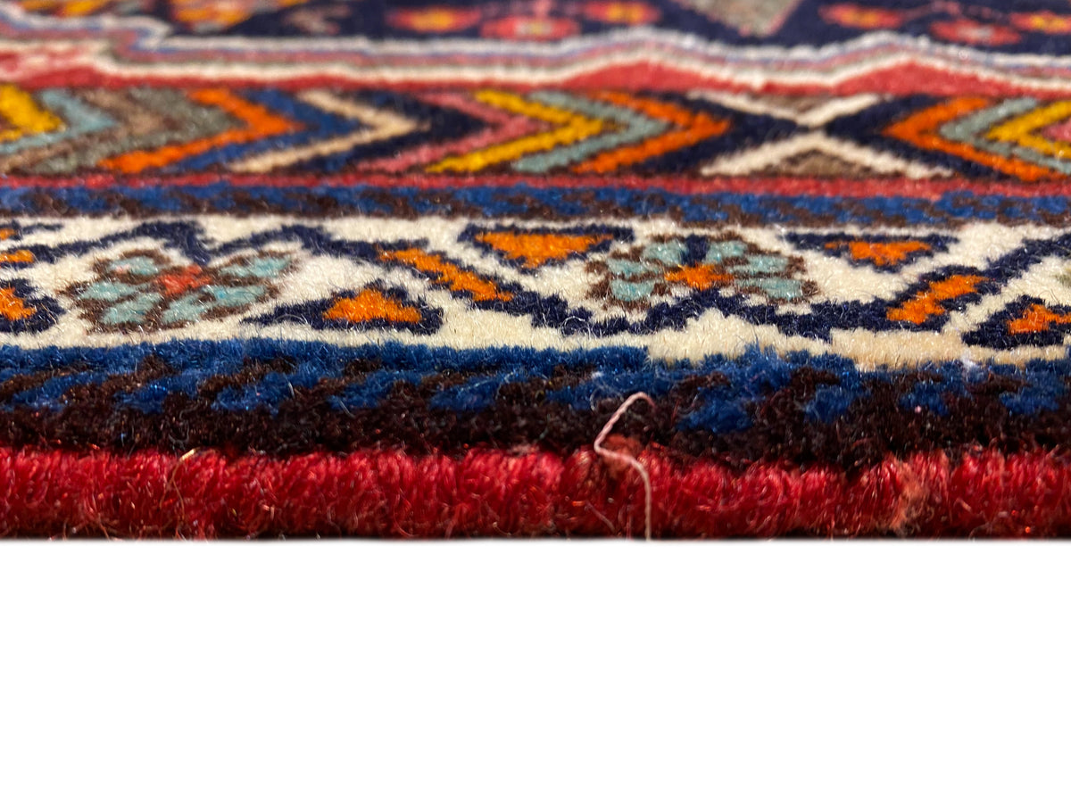 Poshti carpet close-up of the edge with dense pile and a red border
